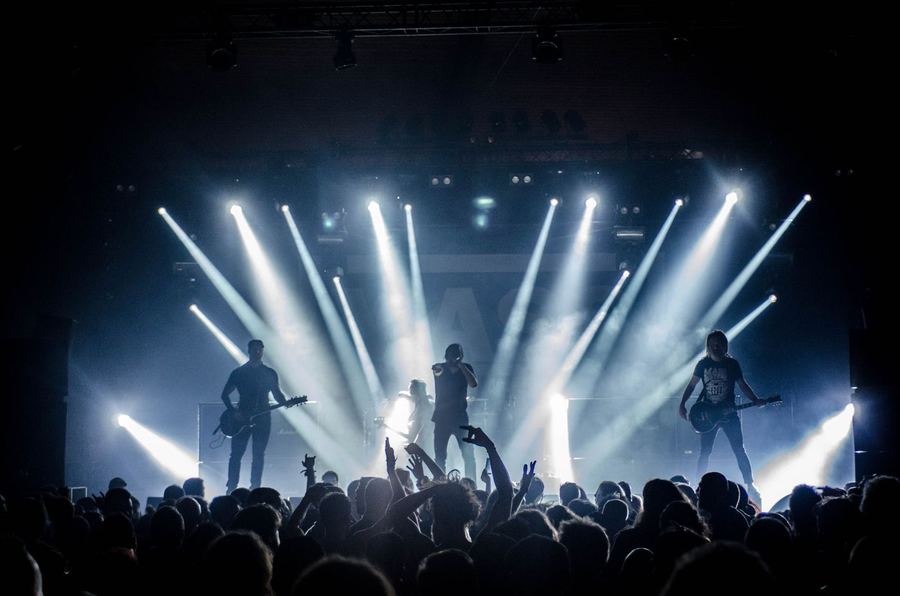 Band sul palco con fasci di luce e americana
